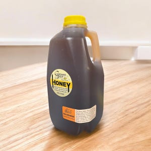 May include: A clear plastic jug of honey with a yellow lid and a label that reads "Gardner Bees Honey" and "Goldenrod". The label also includes the website address www.gardnerbees.com and the text "Our bees make this honey from wildflowers across the heart of Minnesota. Goldenrod is a high pollen honey, which is more robust for its high protein, amino acid, and trace mineral content. Loaded with pollen and a unique flavor profile."