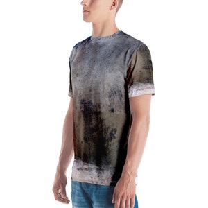 Puede incluir: Una camiseta gris, marr&oacute;n y negra con un patr&oacute;n abstracto desgastado.