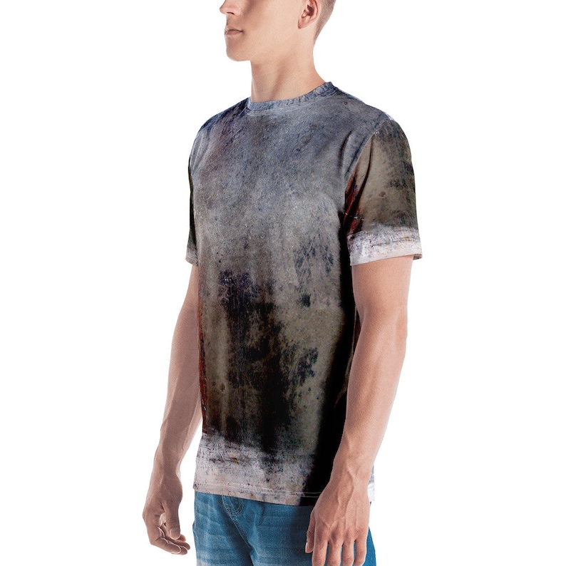 Puede incluir: Una camiseta gris, marr&oacute;n y negra con un patr&oacute;n abstracto desgastado.