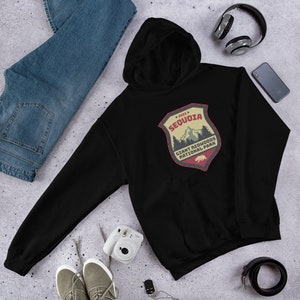 May include: Black hooded sweatshirt with a vintage-style patch featuring a mountain scene and the text "2023 SEQUOIA GIANT REDWOODS NATIONAL PARK".