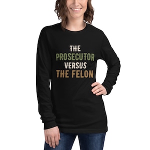 May include: Black long-sleeve shirt with the text "THE PROSECUTOR VERSUS THE FELON" in green, brown, and white.