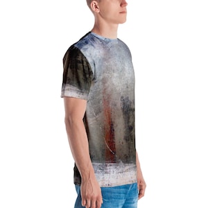Puede incluir: Una camiseta gris, blanca y marr&oacute;n con estampado abstracto y una franja roja en el centro.