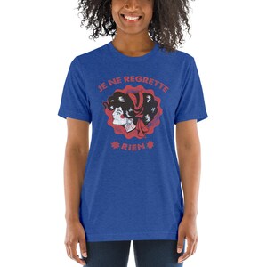 May include: A royal blue t-shirt with a red and white graphic of a woman's face with the text "JE NE REGRETTE RIEN" in red.