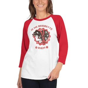 May include: A white and red baseball tee shirt with a vintage-style graphic of a woman's face with the text "Je ne regrette rien" in a circle around her.