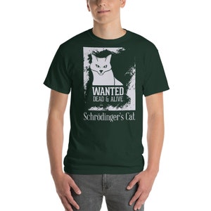 以下が含まれることがあります： 猫と「WANTED DEAD & ALIVE」と「シュレーディンガーの猫」の文字が白で描かれた濃い緑色のTシャツです。