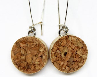 May include: A pair of cork earrings with silver hooks. The earrings are round and have a natural cork texture.