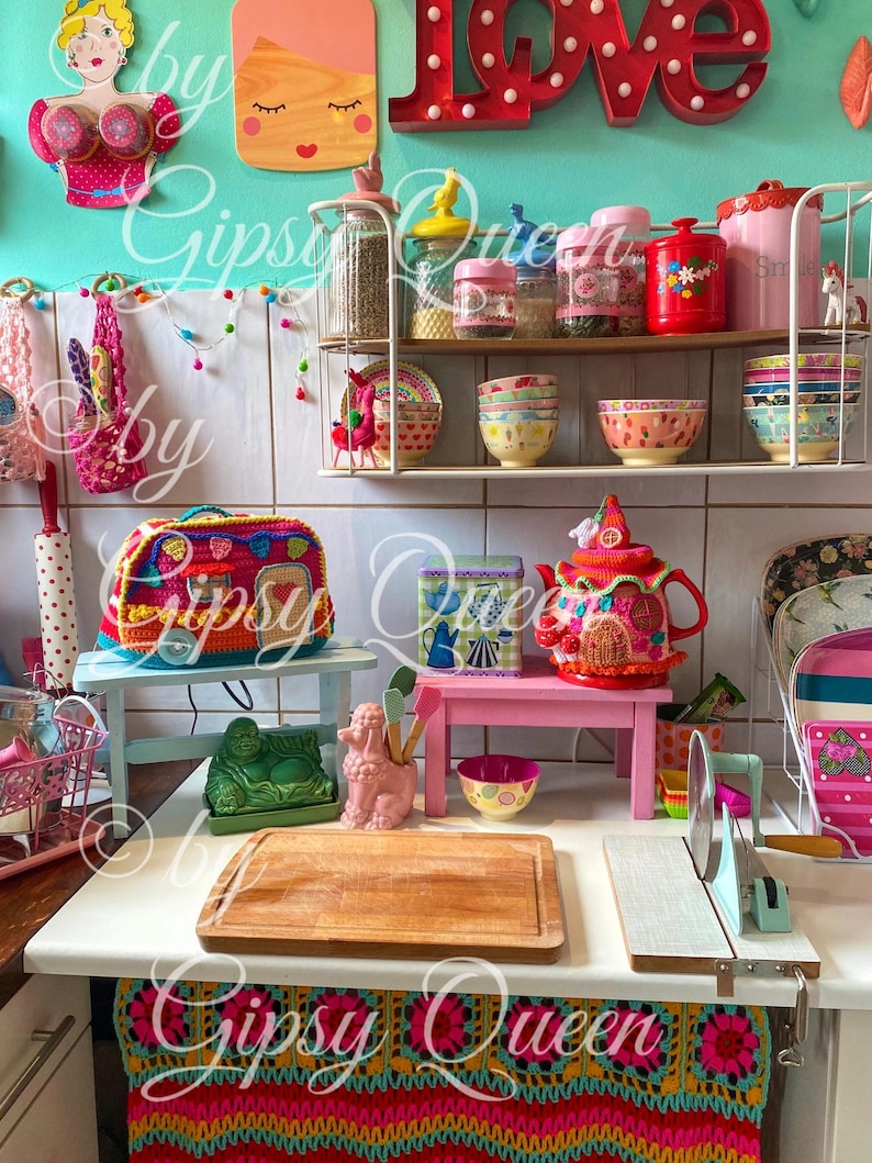 May include: A colorful kitchen scene with decorative items. Includes a crochet bag, a teapot, bowls, jars, and a cutting board. The word "LOVE" is displayed on the wall. The text "Gipsy Queen" is visible in the image.
