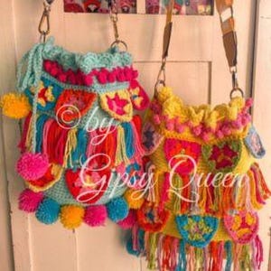 May include: Two colorful crocheted bags with fringe and pom-poms. The bag on the left is turquoise with pink and yellow accents. The bag on the right is yellow with pink, green, and blue accents. Both bags have a long strap.