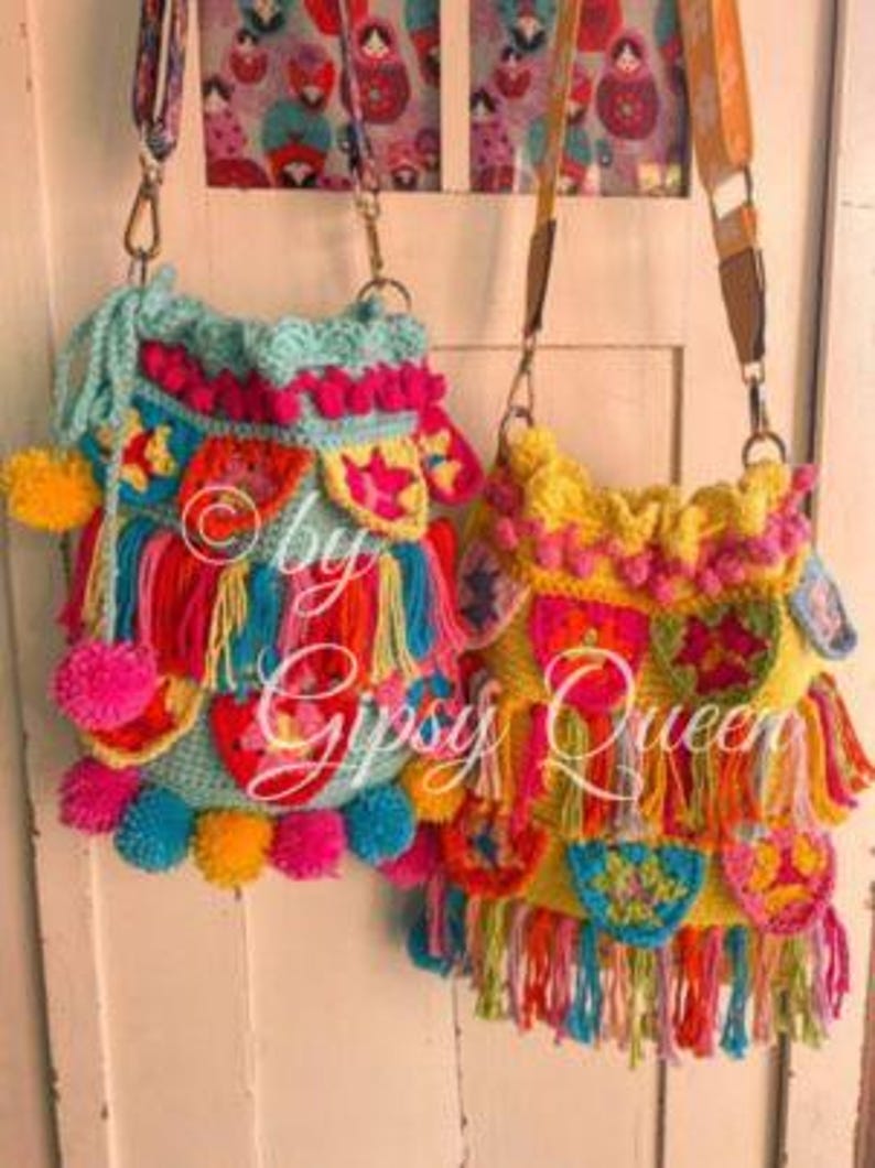 May include: Two colorful crocheted bags with fringe and pom-poms. The bag on the left is turquoise with pink and yellow accents. The bag on the right is yellow with pink, green, and blue accents. Both bags have a long strap.