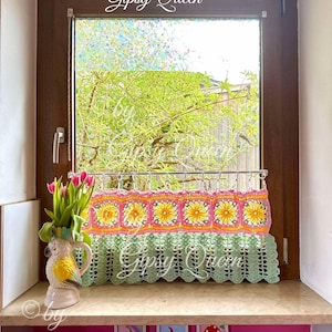 May include: A green crocheted window valance with a pink and yellow floral design. The valance is hanging in a window with a view of green trees. The text "&copy; by Gipsy Queen" is visible in the image.
