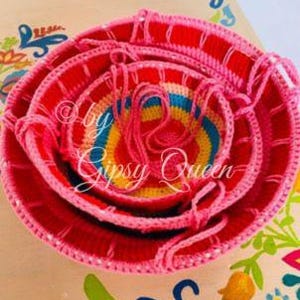 May include: Set of four colorful crocheted bowls, nested together. The bowls are pink, yellow, blue, and green. The bowls are handmade and have a unique, rustic look.