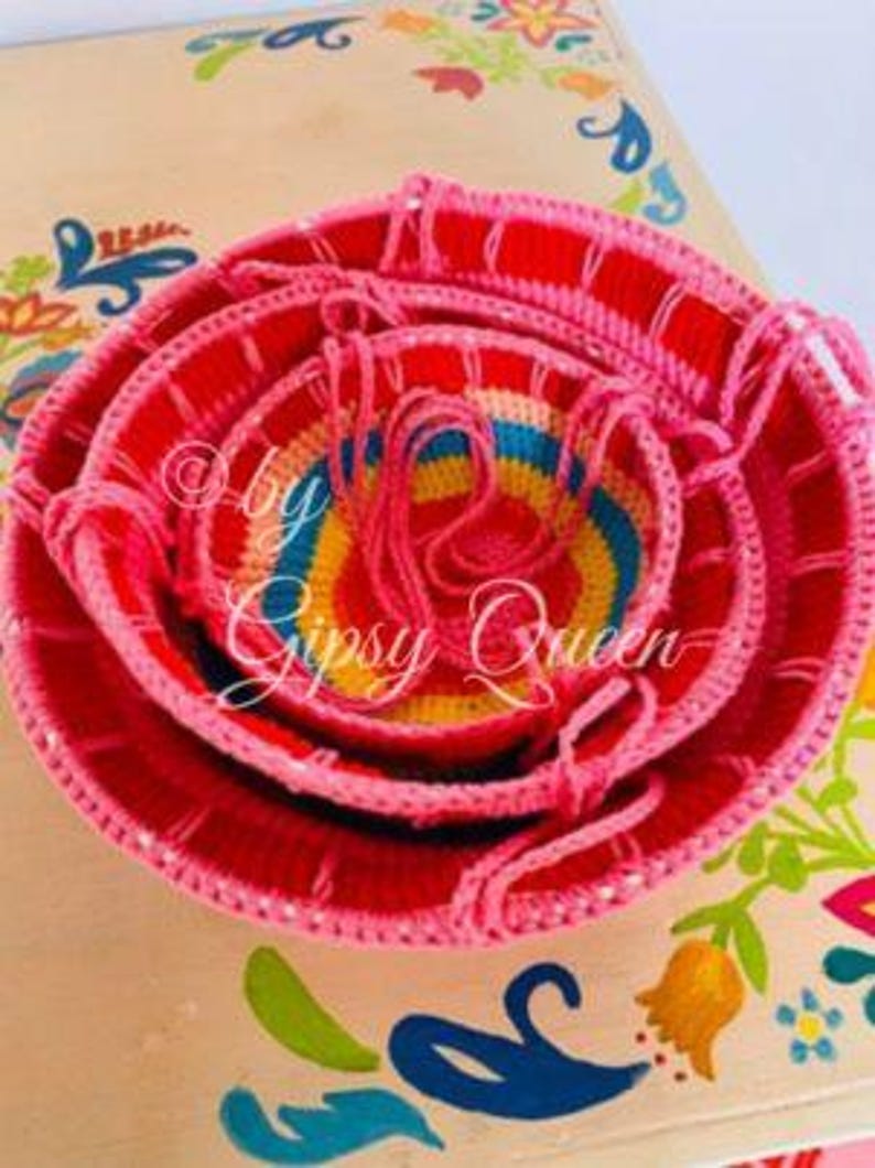 May include: Set of four colorful crocheted bowls, nested together. The bowls are pink, yellow, blue, and green. The bowls are handmade and have a unique, rustic look.