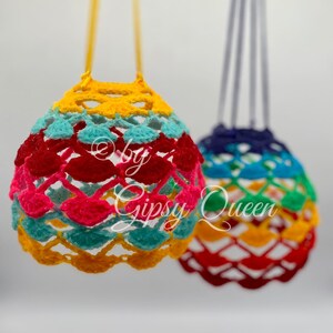 May include: Two crocheted hanging ornaments in rainbow colors. The ornament on the left is yellow, red, pink, blue, and green. The ornament on the right is blue, green, yellow, red, and orange.
