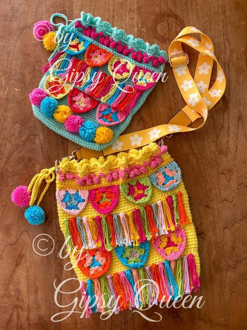 May include: Two crocheted bags with colorful tassels and pom-poms. The bags are yellow and turquoise with floral patterns. The bags have a yellow strap with white flowers.