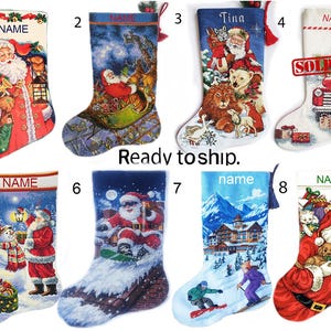 Könnte beinhalten: Acht Weihnachtsstrümpfe mit verschiedenen festlichen Motiven wie Weihnachtsmann, Schneemännern, Winterlandschaften und Tieren. Jeder Strumpf zeigt den Schriftzug NAME oder Tina, den Text Ready to ship und einen roten SOLD OUT Stempel.