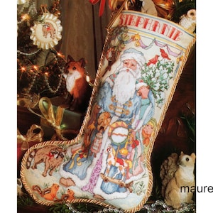 May include: A white Christmas stocking with a gold trim and the name "Stephanie" embroidered on it. The stocking features a Santa Claus figure holding a bag of gifts and surrounded by animals, including squirrels, raccoons, and a fox.