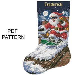 May include: A Christmas stocking cross-stitch pattern featuring Santa Claus snowboarding down a snowy roof. The stocking is personalized with the name "Frederick" at the top. The words "PDF PATTERN" are printed on the left side.