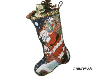 Könnte beinhalten: Ein blauer Weihnachtssocken mit einer Illustration von Weihnachtsmann. Der Weihnachtsmann klettert mit einem Sack voller Spielzeug den Kamin herunter. Der Socken ist mit Geschenken gefüllt und hat eine Tannenzapfen und eine Schleife oben drauf.