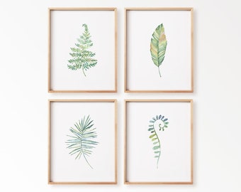 May include: Four framed botanical watercolor prints. Each frame contains a different green leaf design. The leaves are painted in shades of green and yellow, with a white background. The frames are made of light brown wood.