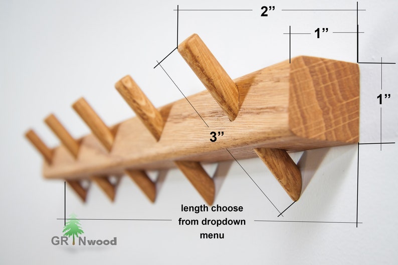 Op de afbeelding: Houten wandbevestigde kapstok met vijf schuin geplaatste haken. De kapstok is 7,6 cm breed, 2,5 cm hoog en 5 cm diep. De haken zijn 2,5 cm lang. De kapstok is gemaakt van natuurlijk hout.