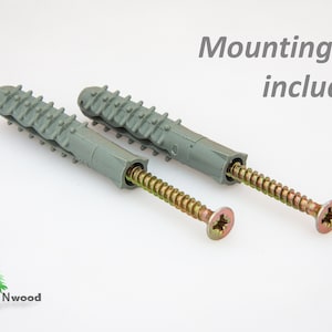 Op de afbeelding: Twee grijze kunststof pluggen met gouden schroeven. De tekst "Mounting Kit included" is zichtbaar in de afbeelding.
