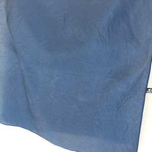 Könnte beinhalten: Ein dunkelblauer Seidenschal mit einem schwarzen Etikett mit der Aufschrift "SOIE MADE IN FRANCE".