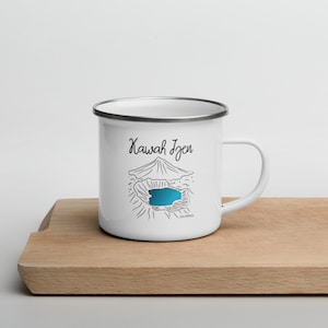 May include: White enamel mug featuring a black line drawing of Kawah Ijen volcano and lake. The text "Kawah Ijen" is written in black cursive on the mug.
