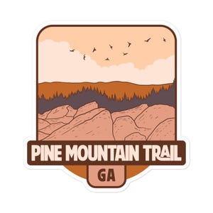 May include: A sticker with a retro illustration of a mountain range with a sunset sky and birds flying overhead. The text "PINE MOUNTAIN TRAIL GA" is printed on the sticker.