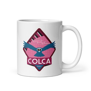 May include: White ceramic mug with a pink and black geometric design featuring a blue bird in flight. The design includes the text "COLCA PERU".