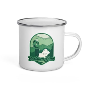 May include: White enamel camping mug with a green illustration of a hiker on the Bartram Trail. The mug has a silver rim and handle.