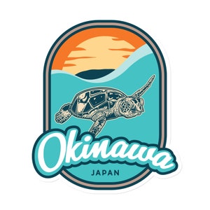 May include: A vintage-style sticker featuring a sea turtle swimming in turquoise water with a sunset in the background. The text "Okinawa, Japan" is written in a stylized font.