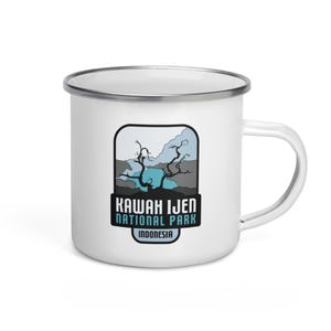 May include: White enamel camping mug featuring a blue and grey illustration of a tree and a lake. The text "Kawah Ijen National Park Indonesia" is printed on the mug.