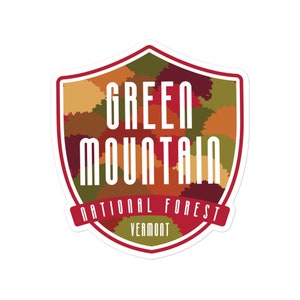 May include: A red, white, and green shield-shaped sticker with the text "Green Mountain National Forest Vermont". The shield is filled with a camouflage pattern of green, brown, and red.