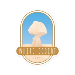 Puede incluir: Una pegatina ovalada dorada con un paisaje de desierto blanco. La pegatina presenta una formación rocosa blanca con forma de hongo, un cielo azul y el texto "WHITE DESERT EGYPT".