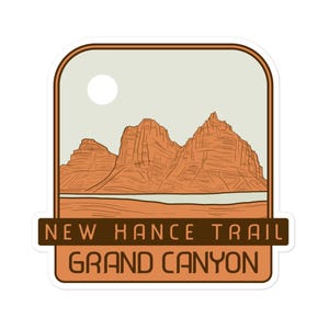 May include: A sticker featuring a vintage illustration of the Grand Canyon's New Hance Trail. The sticker depicts a brown mountain range against a light brown sky with a white sun.