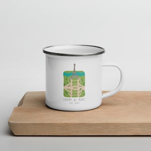 May include: White enamel mug with a silver rim featuring a green, blue, and white illustration of the Eiffel Tower and Champ de Mars in Paris, France. The text "Champ de Mars, Paris, France" is printed below the illustration.