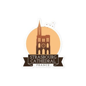 May include: A sticker featuring a silhouette of Strasbourg Cathedral in France, with a sunset-colored background and a banner reading "Strasbourg Cathedral, France".