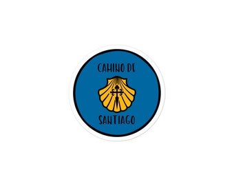 May include: A blue and white circular sticker with the text "Camino de Santiago" and a yellow scallop shell with a cross inside.