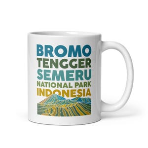 May include: White ceramic mug with a colorful graphic design featuring the text "Bromo Tengger Semeru National Park Indonesia". The graphic also includes a stylized mountain range.