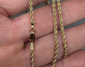 May include: A gold rope chain necklace with a lobster clasp.