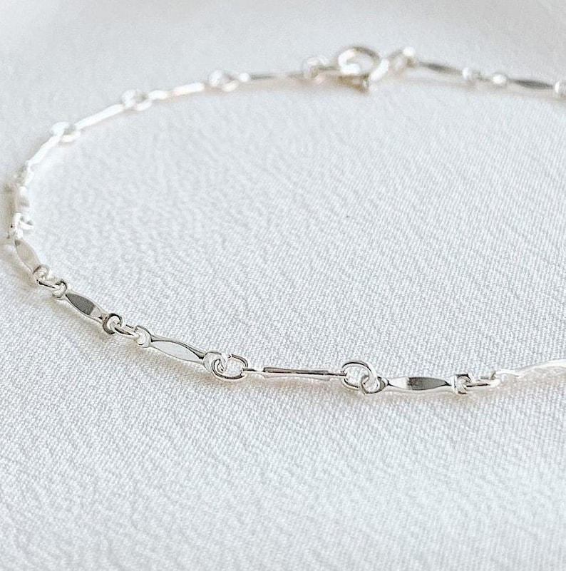 A dainty sterling silver bracelet crafted with dapped bar chain.  Each marquise shaped segment is flattened and then attached to the next segment by a ring. The bracelet has a spring ring closure.