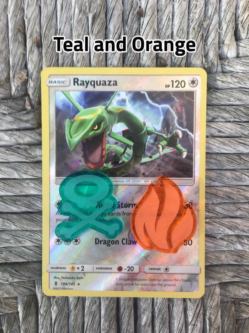Puede incluir: Carta Pok&eacute;mon Rayquaza del set Teal and Orange. La carta presenta una ilustraci&oacute;n verde y naranja de Rayquaza con el texto "Rayquaza" y "PS 120" en la esquina superior derecha. La carta tambi&eacute;n tiene tres ataques: "Tormenta", "Garra de Drag&oacute;n" y "Ataque A&eacute;reo".