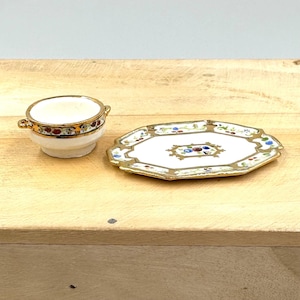 May include: A white porcelain bowl with a gold rim and floral design, and a matching white porcelain octagonal plate with a gold rim and floral design.