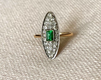 An 18 karat gold with platinum diamond and emerald navette ring