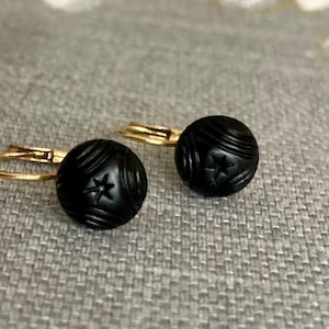 Un par de pendientes de estrella de oro y azabache de Italia.