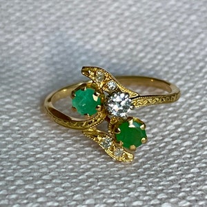 An 18 karat French diamond and emerald toi et moi ring