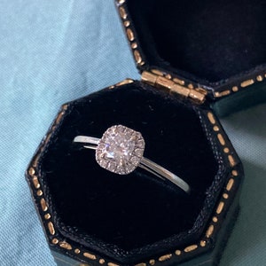 An 18 karat white gold vintage engagement cluster ring featuring a princess cut diamond of ca. 0.30 ct.