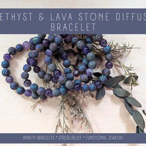 May include: Amethyst and lava stone diffuser bracelets with text that reads "AMETHYST & LAVA STONE DIFFUSER BRACELET". The bracelets are made of purple and blue beads. The bracelets are displayed with dried plants. The text at the bottom reads "ANXIETY BRACELETS * STRESS RELIEF * FUNCTIONAL JEWELRY".