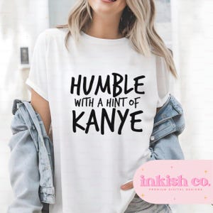 May include: White t-shirt with black text that reads "Humble with a hint of Kanye".