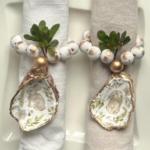 May include: A white ceramic mug with a black handle and the text "But first, coffee" in a black, handwritten-style font. The mug is on a white surface.